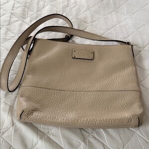 Kate Spade cream colored crossbody with adjustable strap.